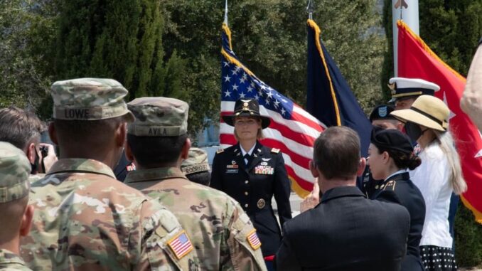 a woman in uniform stands in a crowd